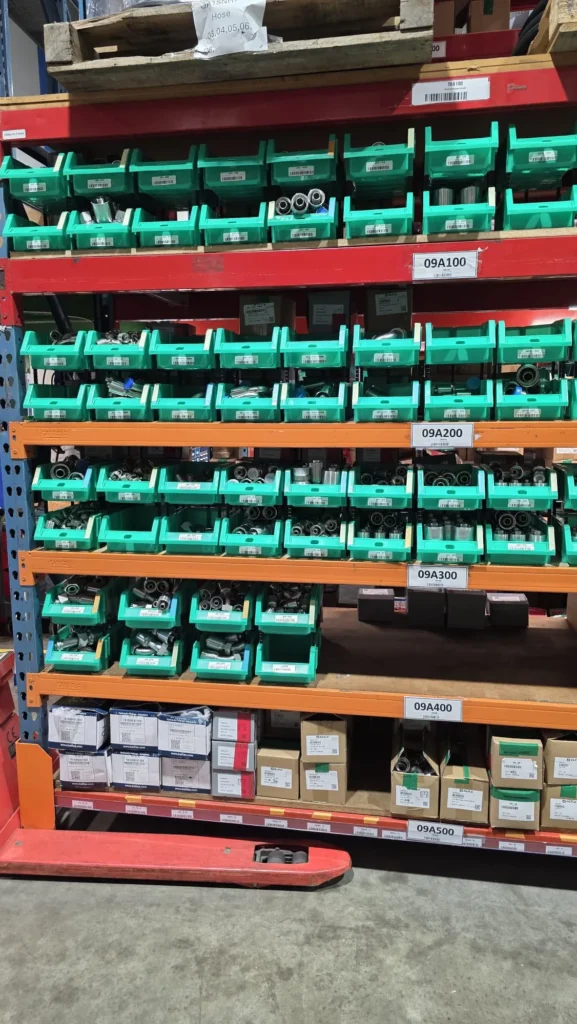 Hydraulic fittings stored in labeled bins for industrial inventory management